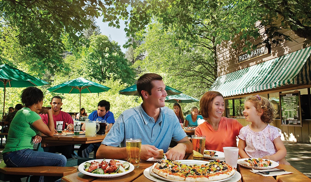 Family enjoys pizza at a Yosemite Valley restaurant, the Curry Village Pizza Deck.