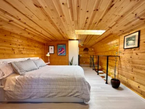 loft bedroom with wood paneled walls and ceiling