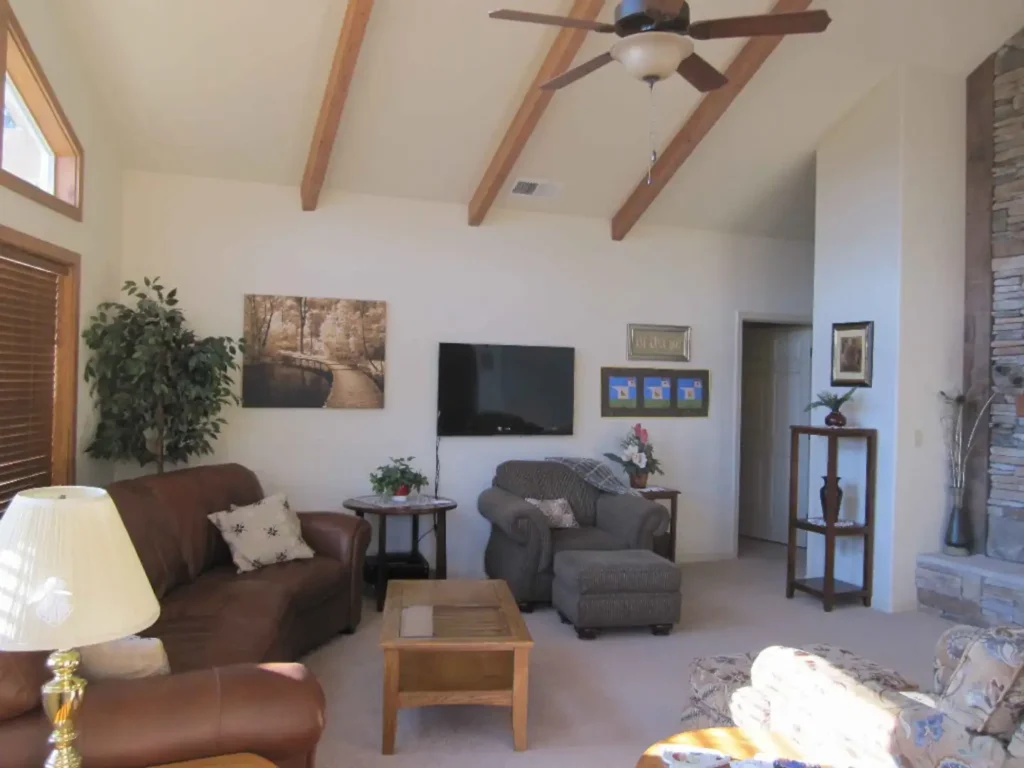 living room with tall ceilings, fireplace and television