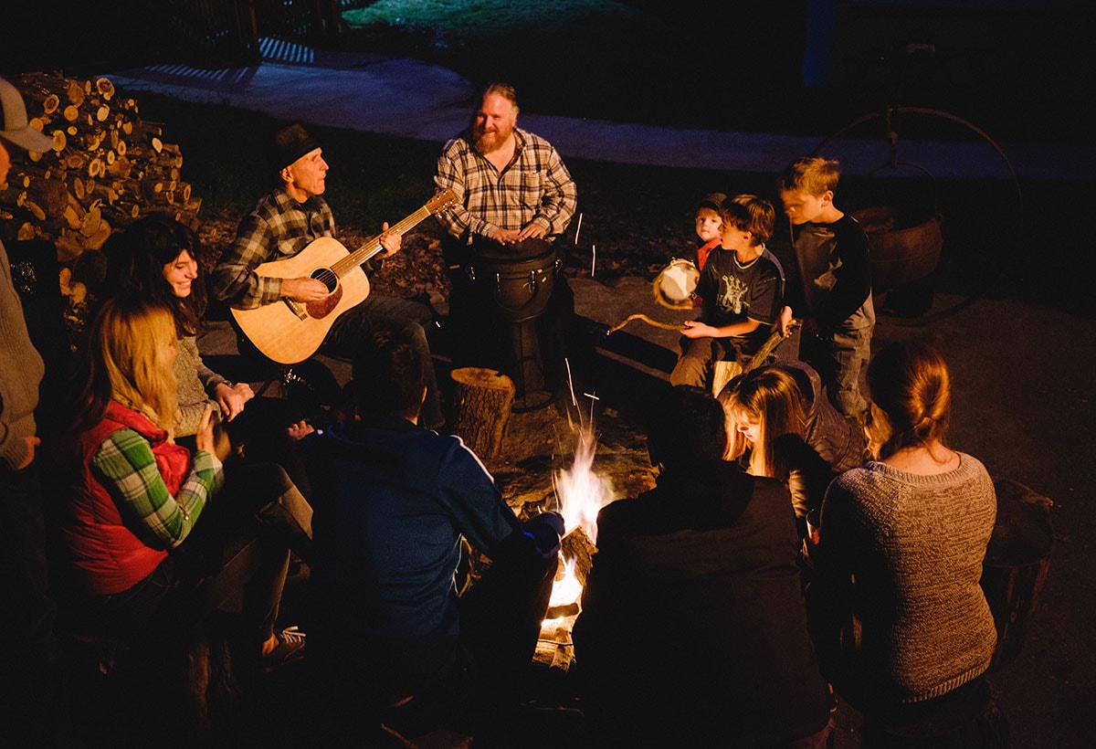 People gathering around the campfire at the Yosemite Bug Rustic Mountain Resort