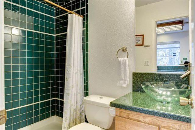 bathroom with green tiles and bathtub