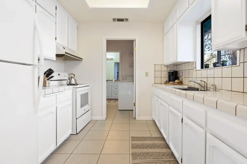 galley kitchen with white appliances and cabinets