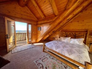 bedroom with queen and twin beds, log cabin ceiling and walls