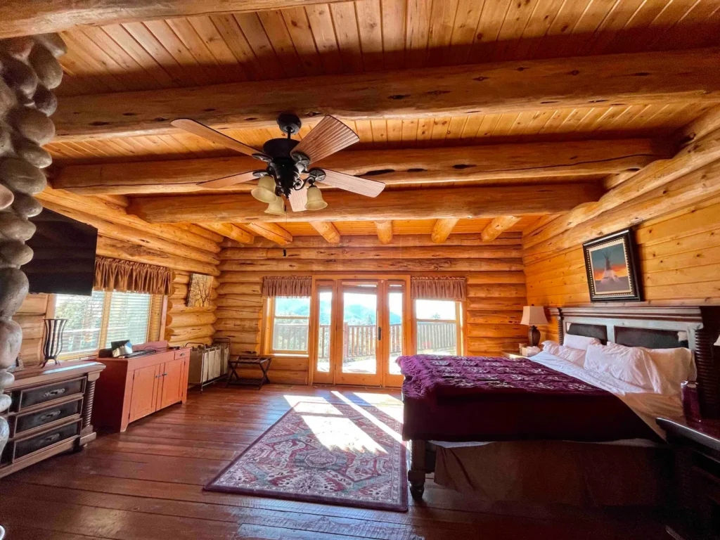 primary bedroom with log cabin beams