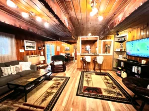 living room with wood ceiling and floors and couches and view of kitchen and television