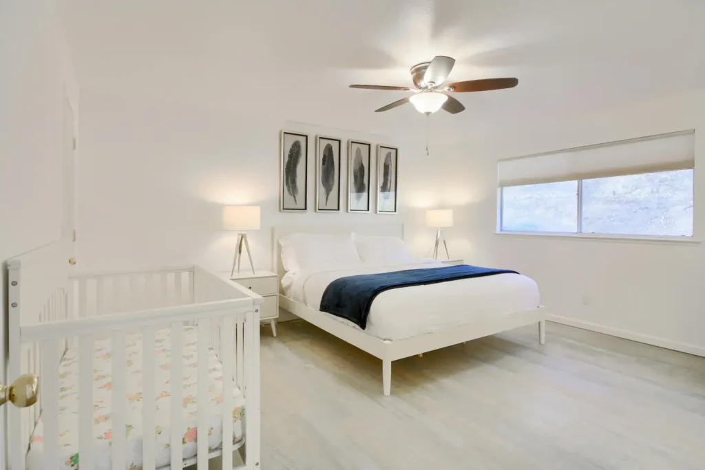 primary bedroom with queen bed and. crib