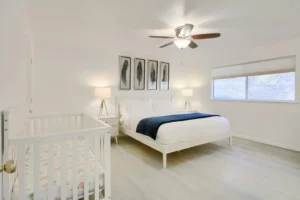 primary bedroom with queen bed and. crib
