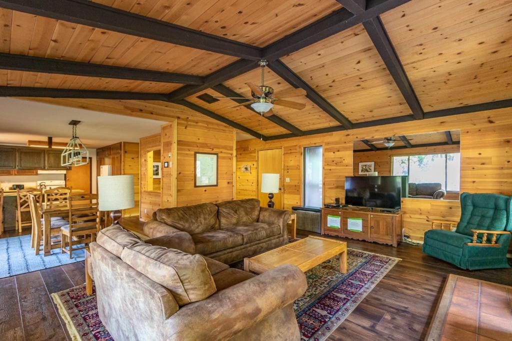 living room with beamed ceilings, couches and television