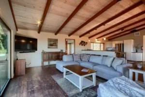 living room wit beams, television and couch