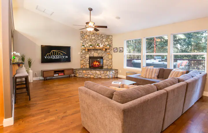 living room with television and stone fireplace