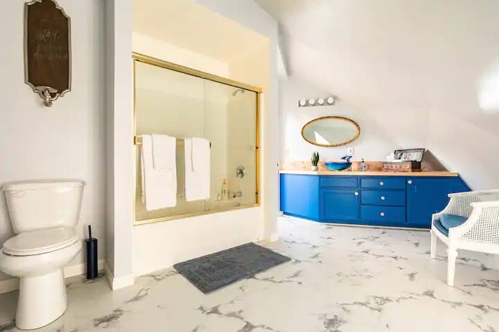 bathroom with blue vanity and shower tub