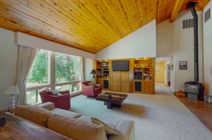 living room with tall wood ceilings, wood stove, and seating