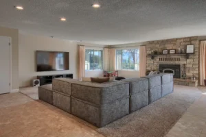 living room with sectional couch, television, and fireplace