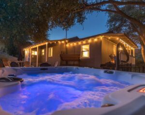 night view of hot tub with lights