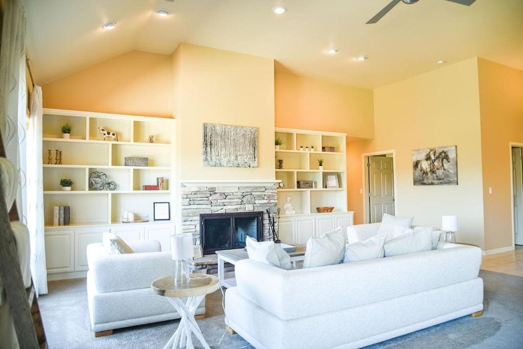 living room with fireplace white couches and bookshelves