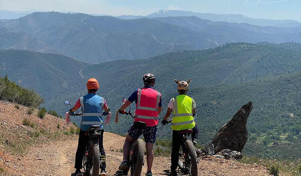 3 people on an e-bike tour looking out over the Sierra Nevada foothills