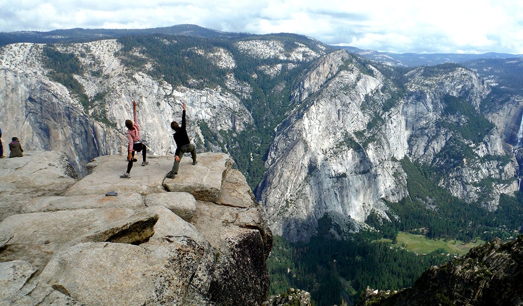 People doing yoga at Taft Point, a Yosemite scenic overlook