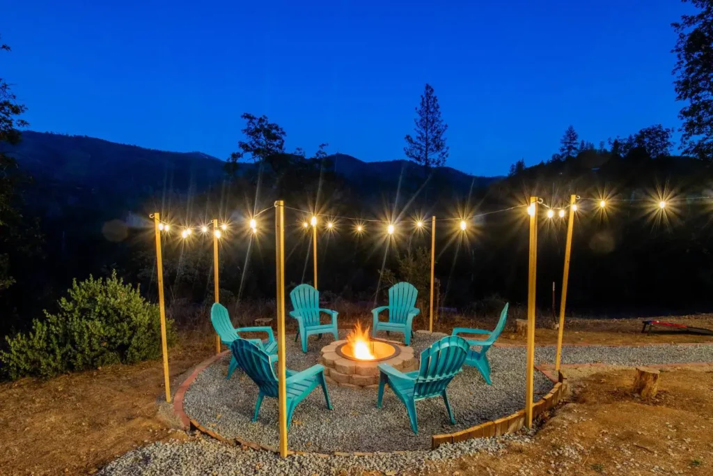 fire pit with blue chairs and string lights