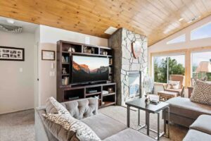 living room with large couch, fireplace, and television