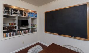 kids room with blackboard television, dvds, and books