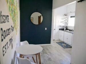 entryway with mirror, small table seating and kitchen