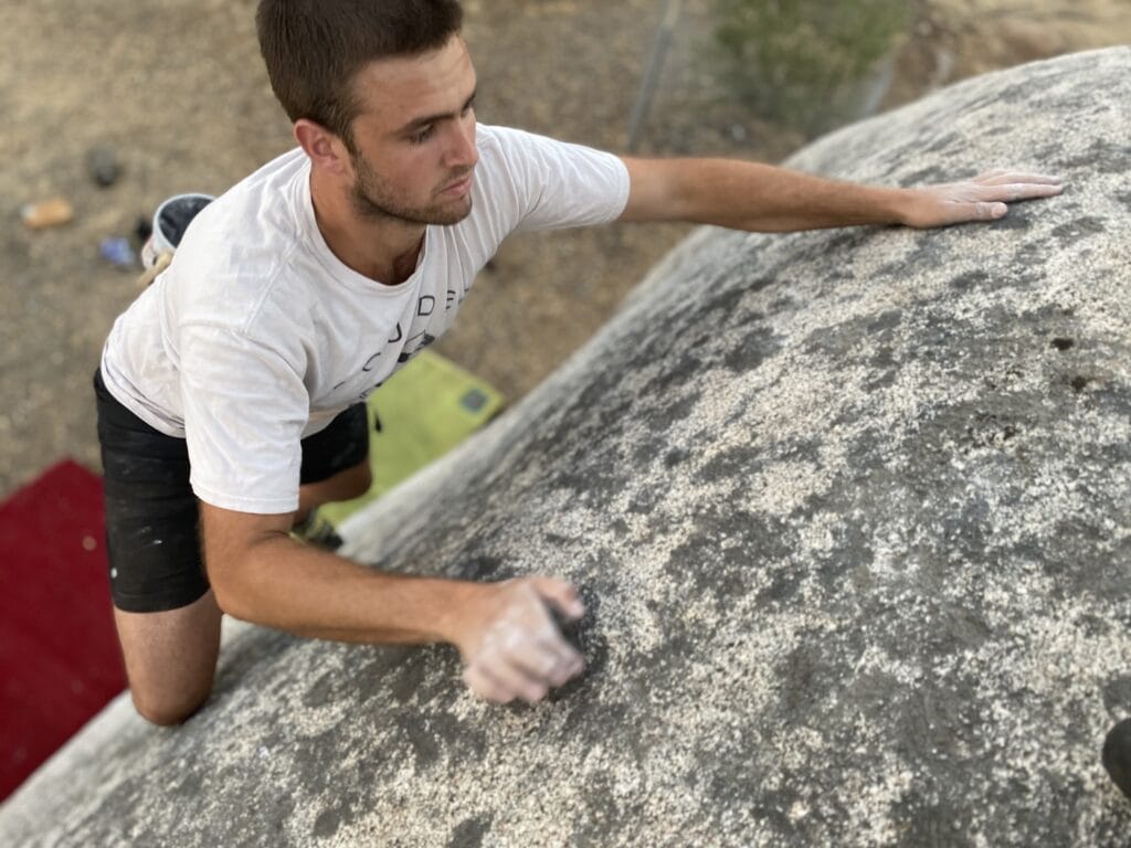 man climbing boulder